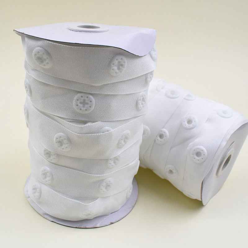 White snap fastener button tape roll, fabric strip with evenly spaced snap buttons