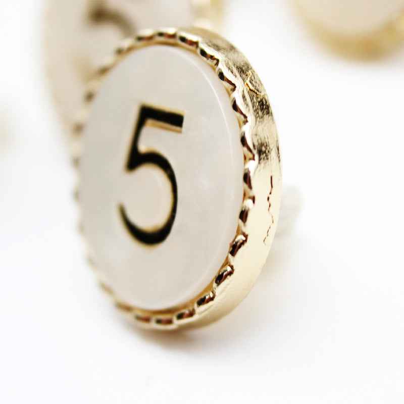 Number 5 resin shank button angled front, black “5” on white with gold border