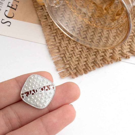 Silver square metal button with pearl-style studs and decorative geometric cutout