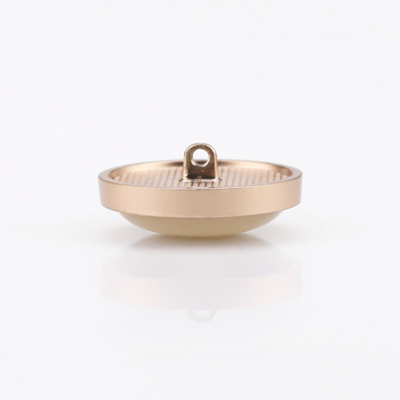 Cat-eye shank button side view with visible metal shank hole and pearly front