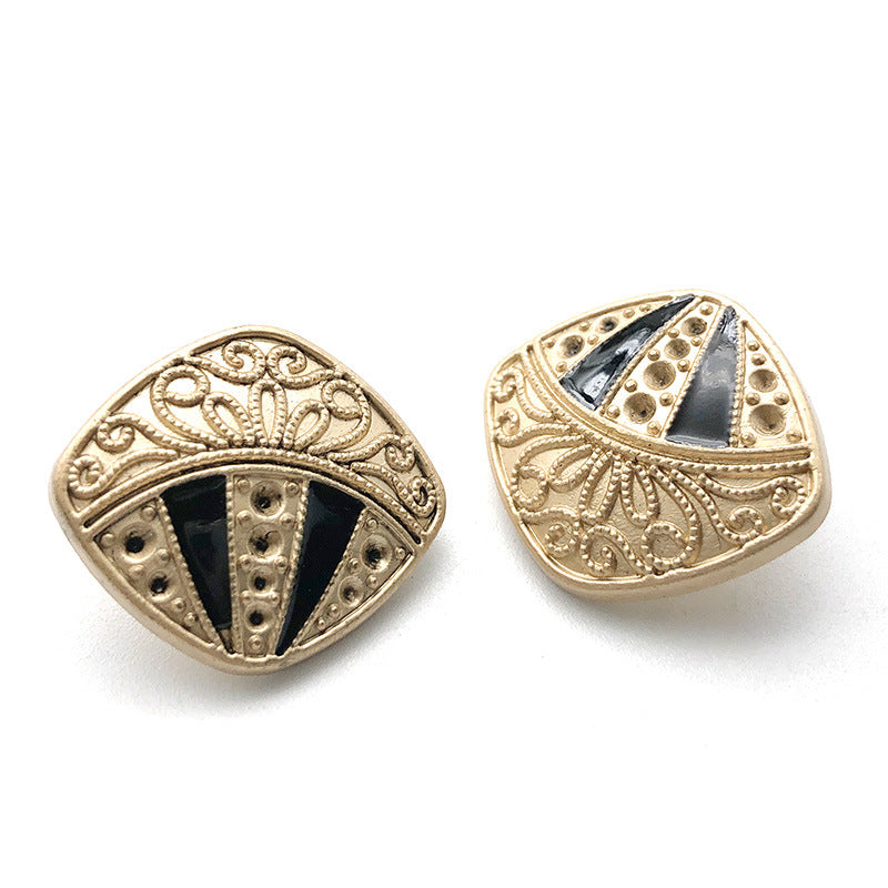 Gold-tone metal shank button with faceted diamond inlays and dark center panel