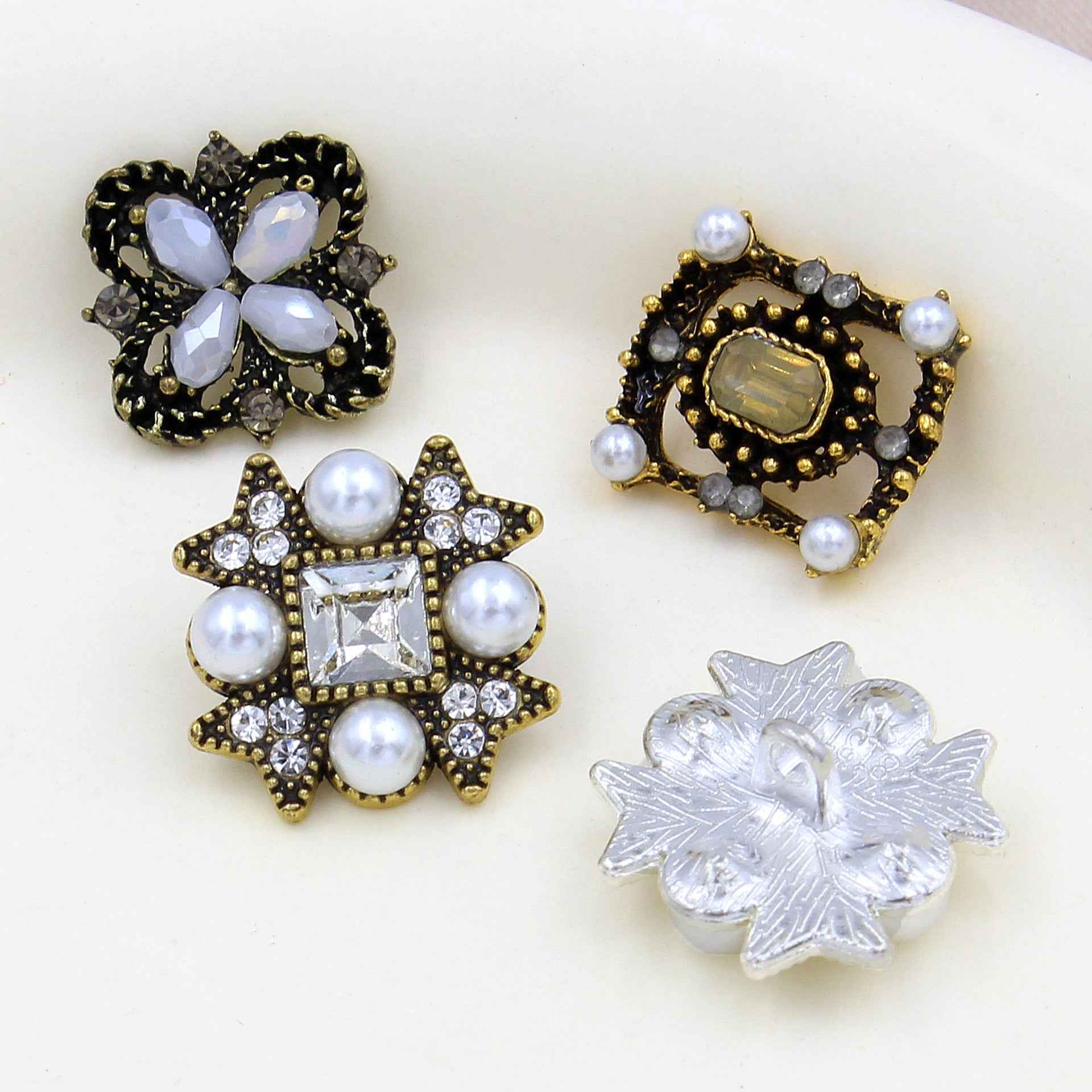 Gold star shank button with pearls and rhinestones; silver snowflake button