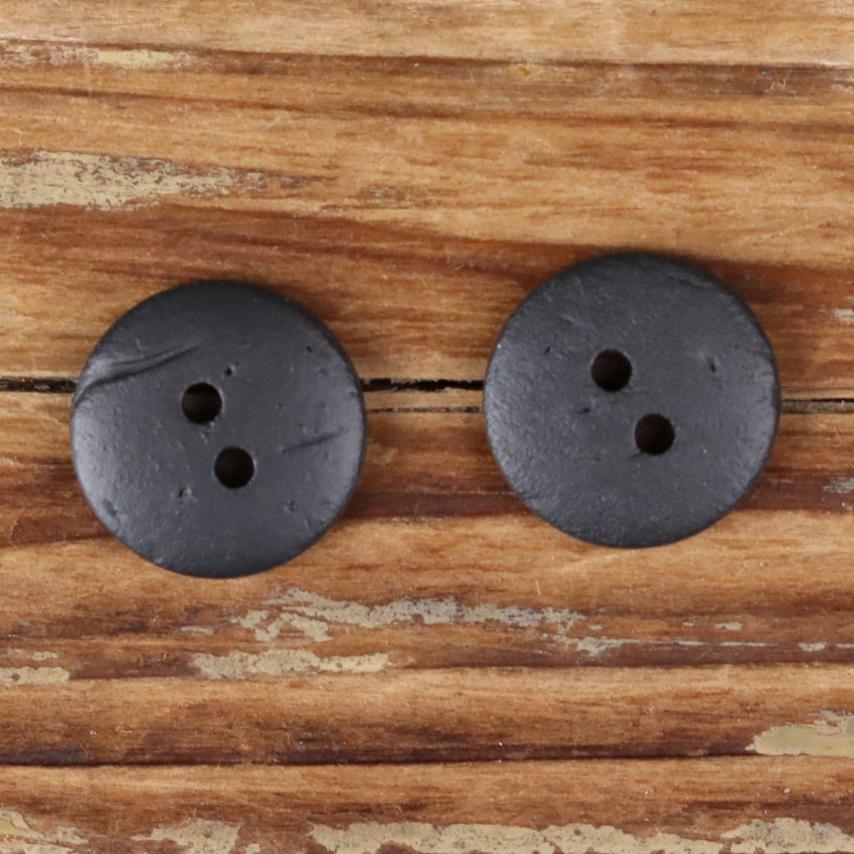 Set of two round 2-hole dark coconut shell buttons, textured surface