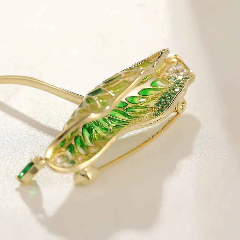Close-up green enamel lotus leaf brooch pin with dangling waterdrop zircon