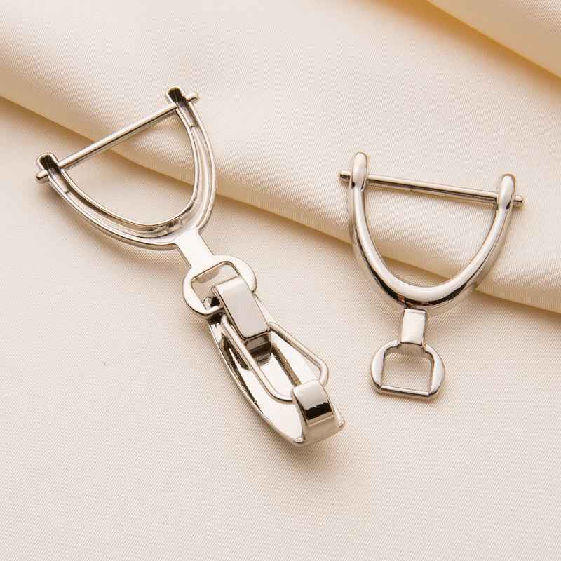 Close-up of silver coat hook buckle: D-ring hooks with snap clasp mechanism