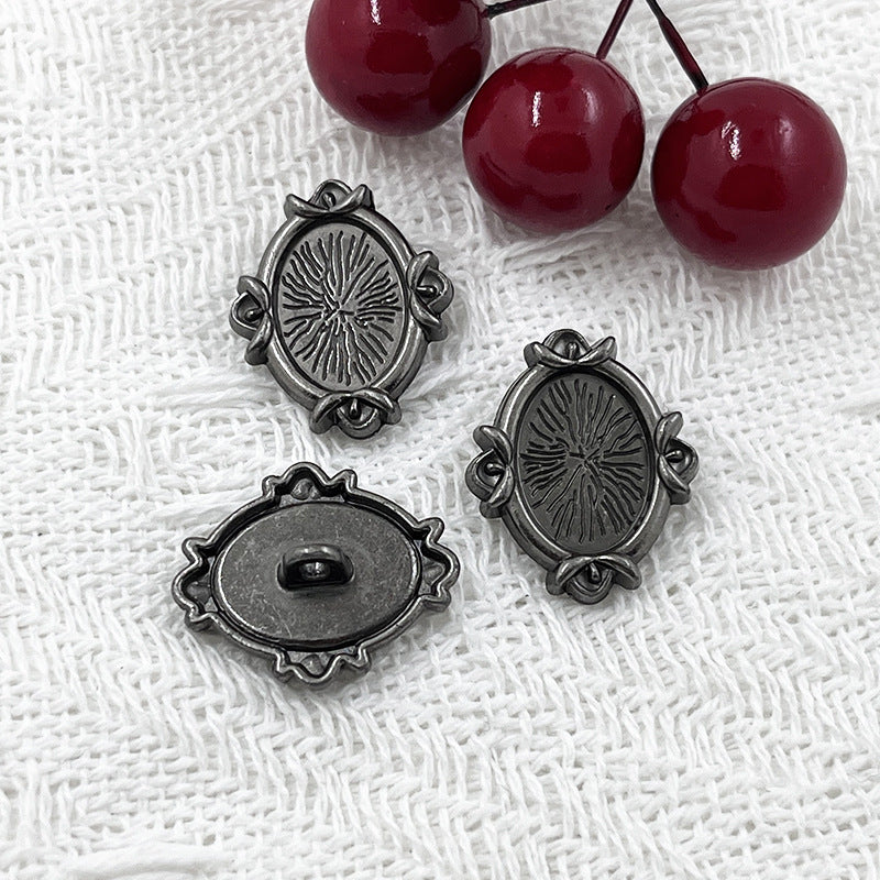 Black oval metal shank buttons with engraved floral motif; matching metal loop shanks