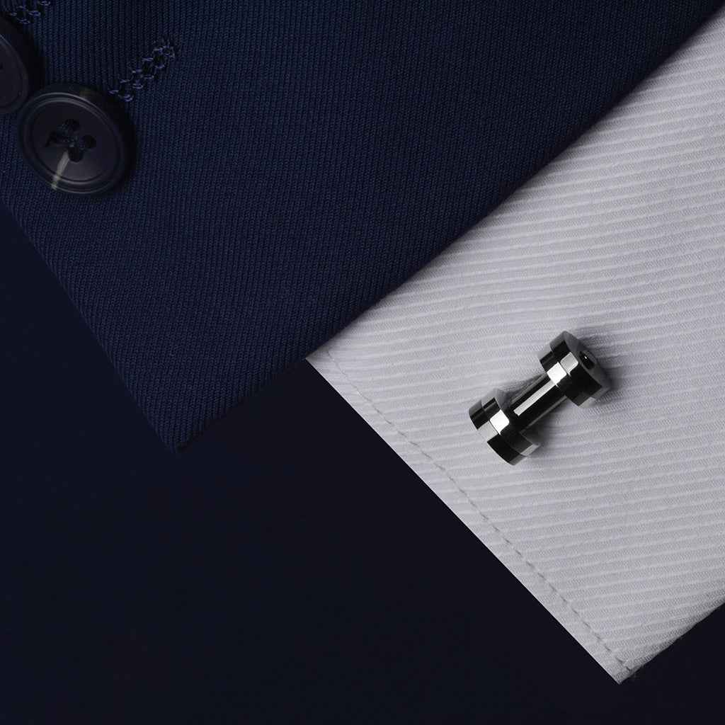 Silver & gunmetal dumbbell cufflinks clipped to shirt cuff