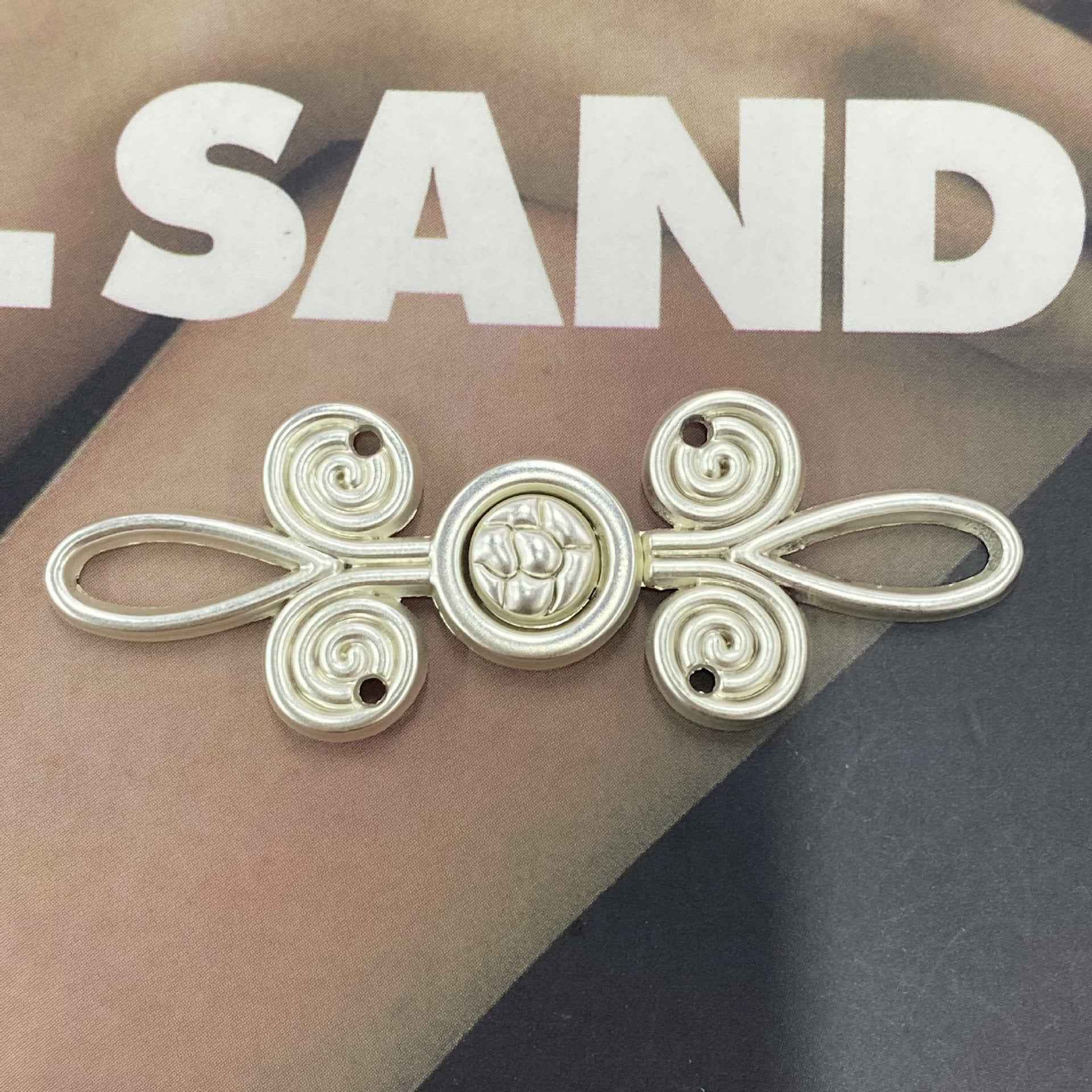 Silver-tone metal frog button (Style 8), four spiral corner loops with central round medallion