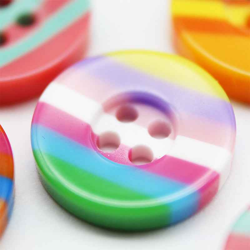 Close-up: colorful 4-hole resin button with rainbow stripes, wide edge