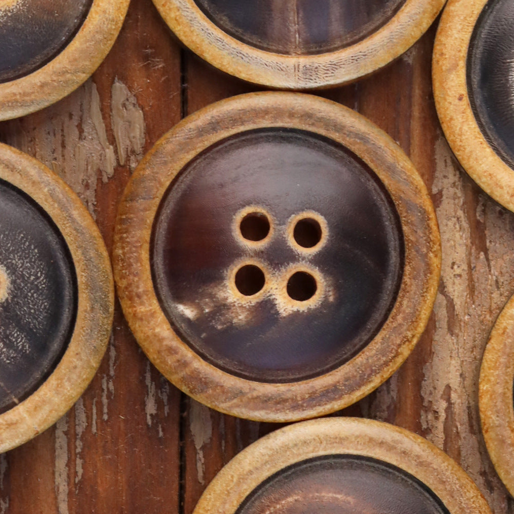 Round 4-hole coat button with dark face and burnished tan border