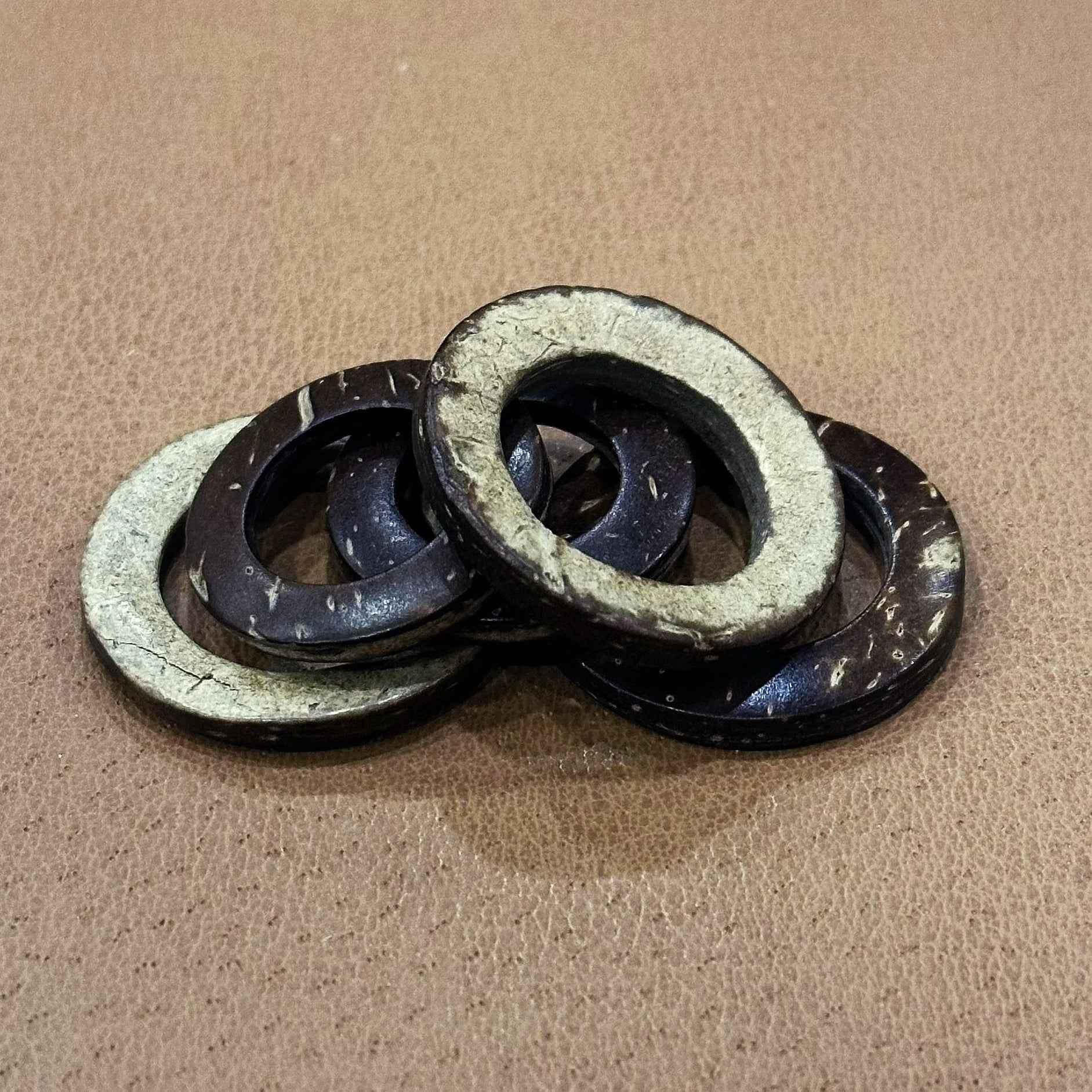 Coconut shell ring buttons, dark outer rings with light greenish outer edges and holes