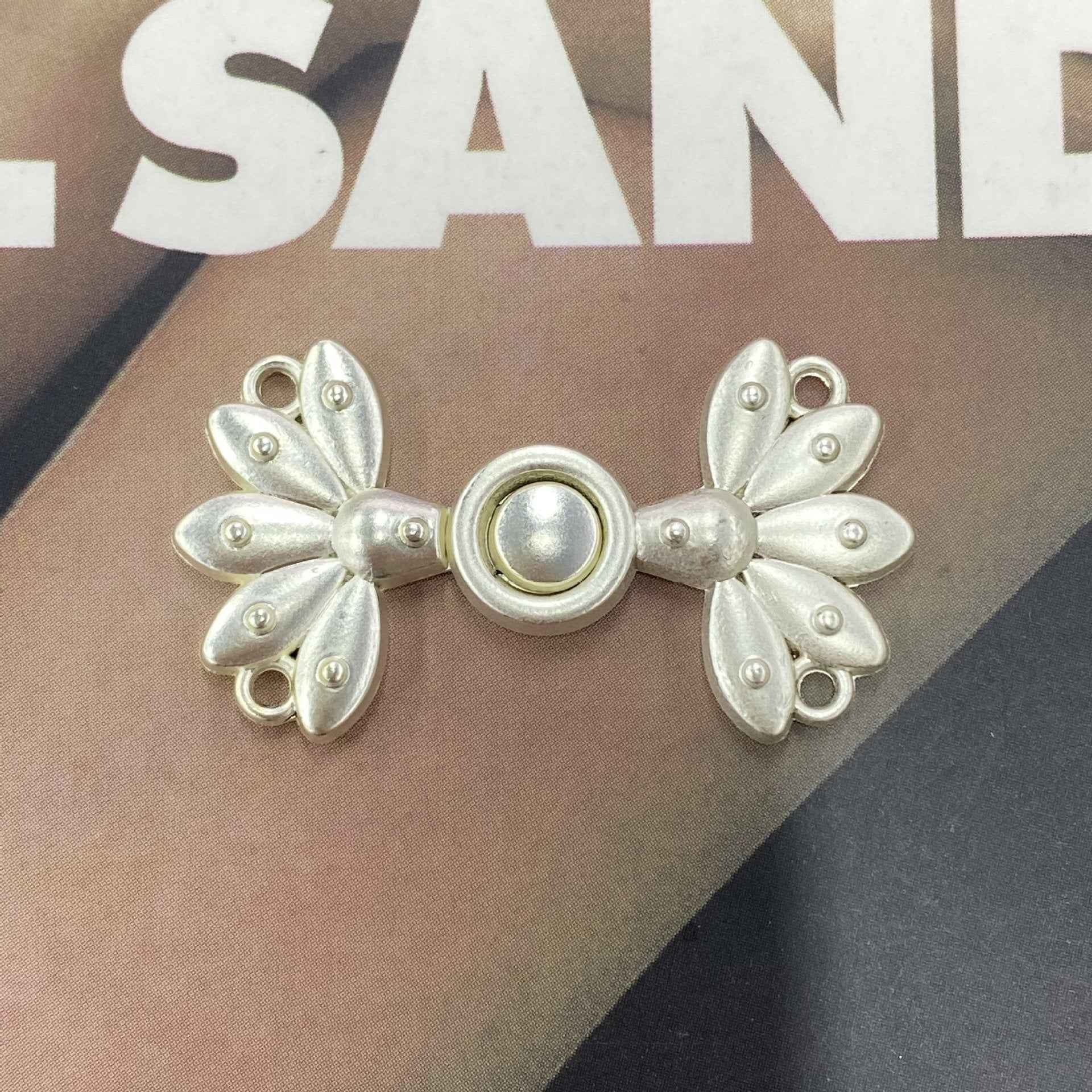 Silver-tone metal frog button (Style 5), butterfly-flower petals around a round bead center