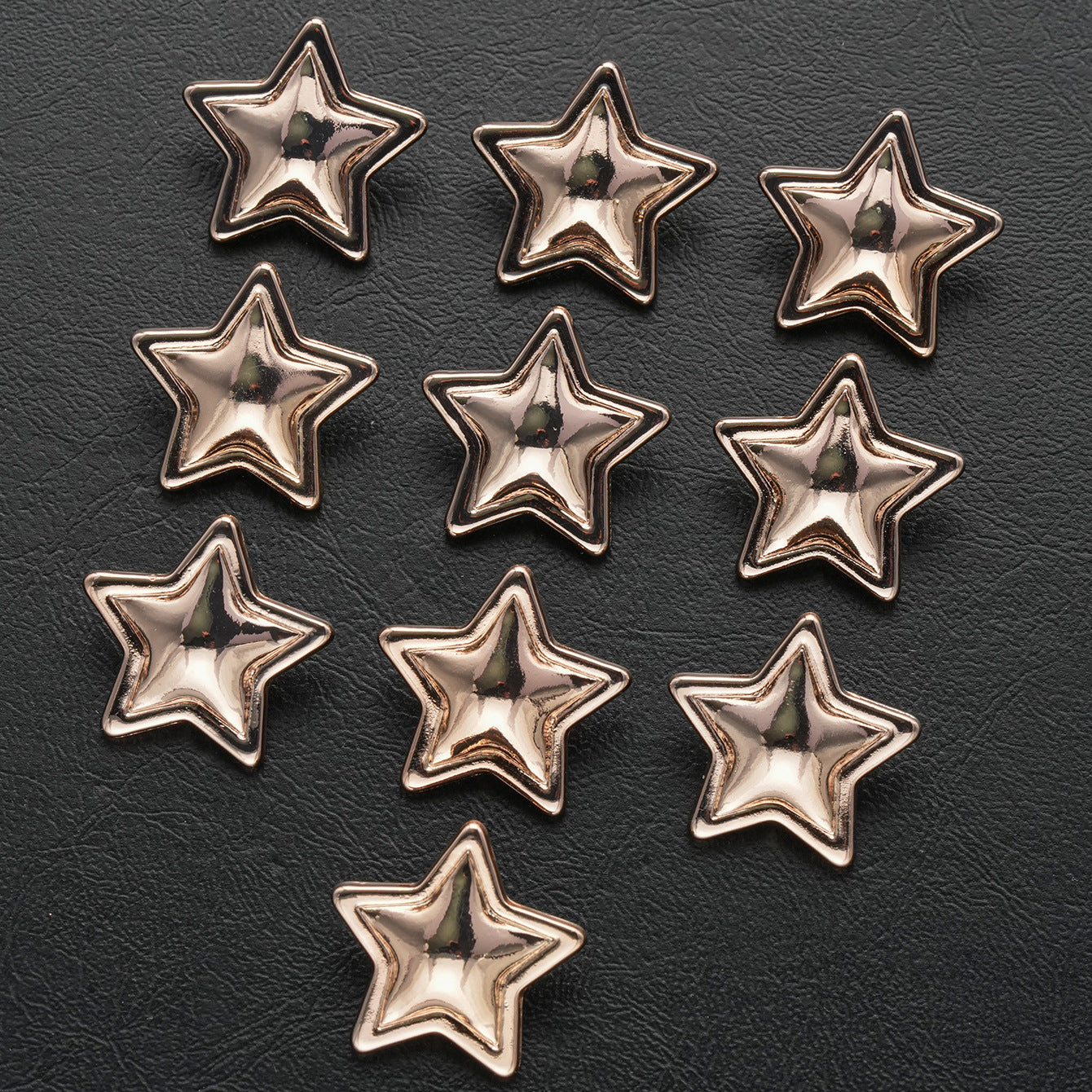 Gold star-shaped metal shank buttons, 20-pack, arranged in rows on dark surface