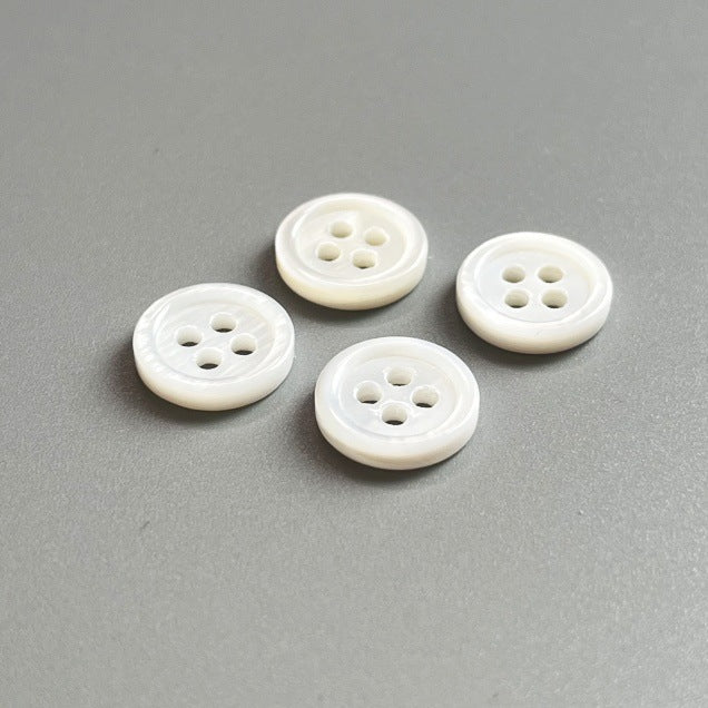 14L-24L natural white pearl shell button, round, four-hole; four pieces shown