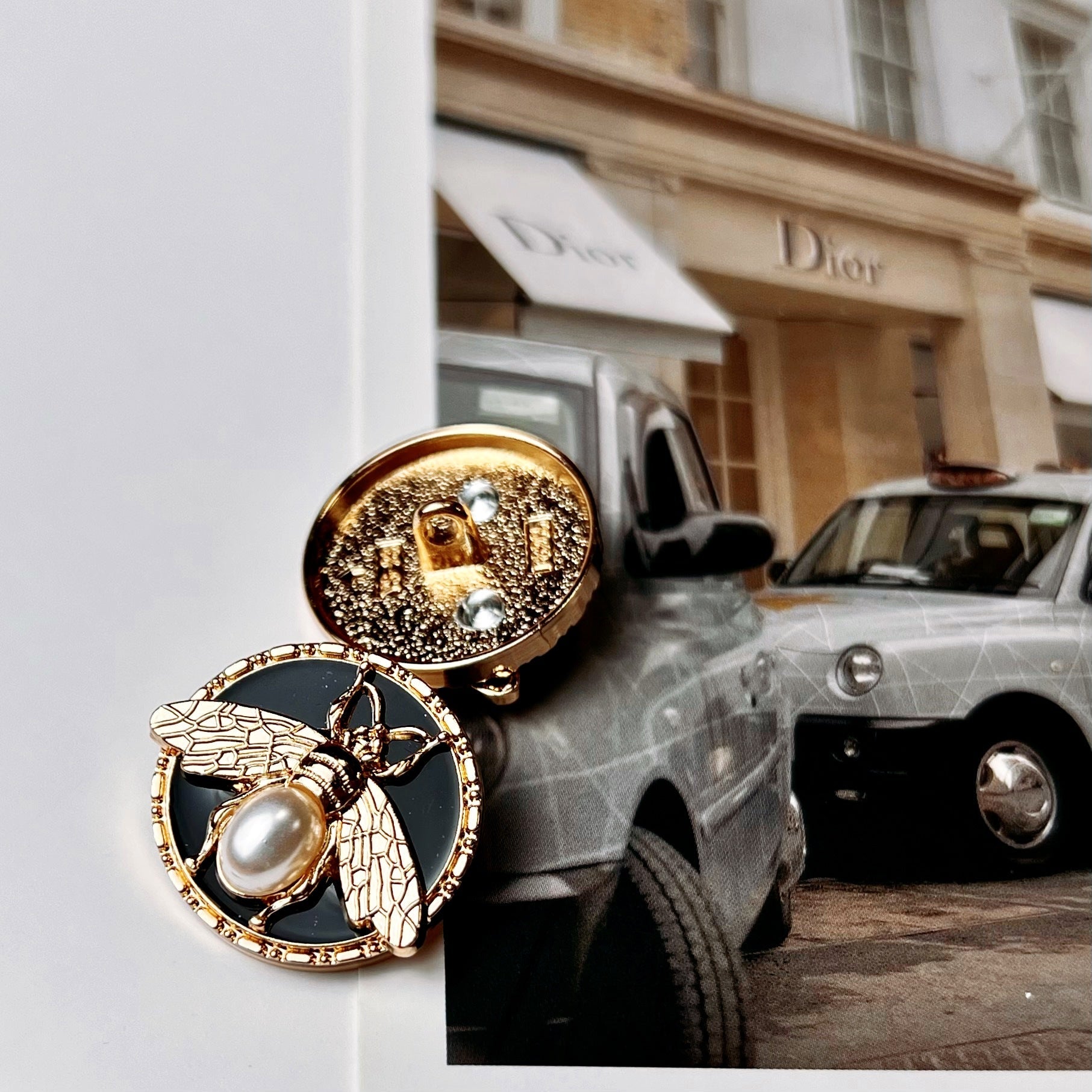 Gold bee pearl metal shank button with oval pearl center on black enamel