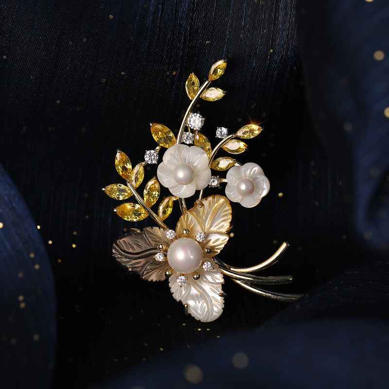 Tri-color floral brooch with white pearls, golden leaf accents, and rhinestone details