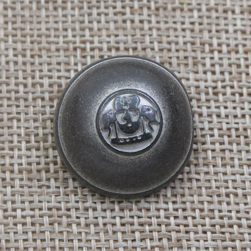 Ein einzelner runder Schankknopf, silbergrau, mit geprägtem Kronen-Emblem
