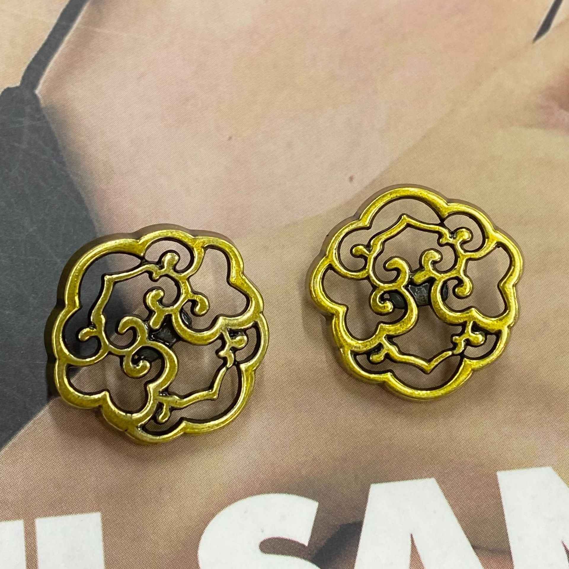 Two gold metal shank cloud buttons with ornate cutout design