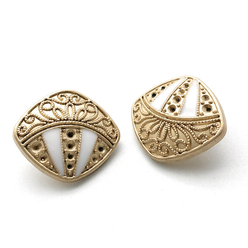 Gold-tone metal shank button with white inset, rhinestone band, ornate edge