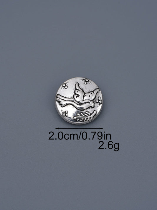 Silver-toned embossed metal shank button with flying bird design, ~2.0cm
