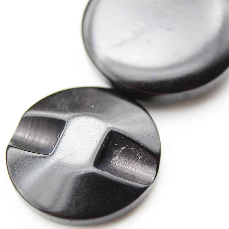 Close-up of black hidden-hole resin button with cross-shaped slots