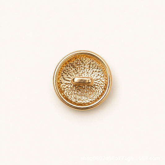 Round metal shank button, textured gold back with oval shank and gold rim