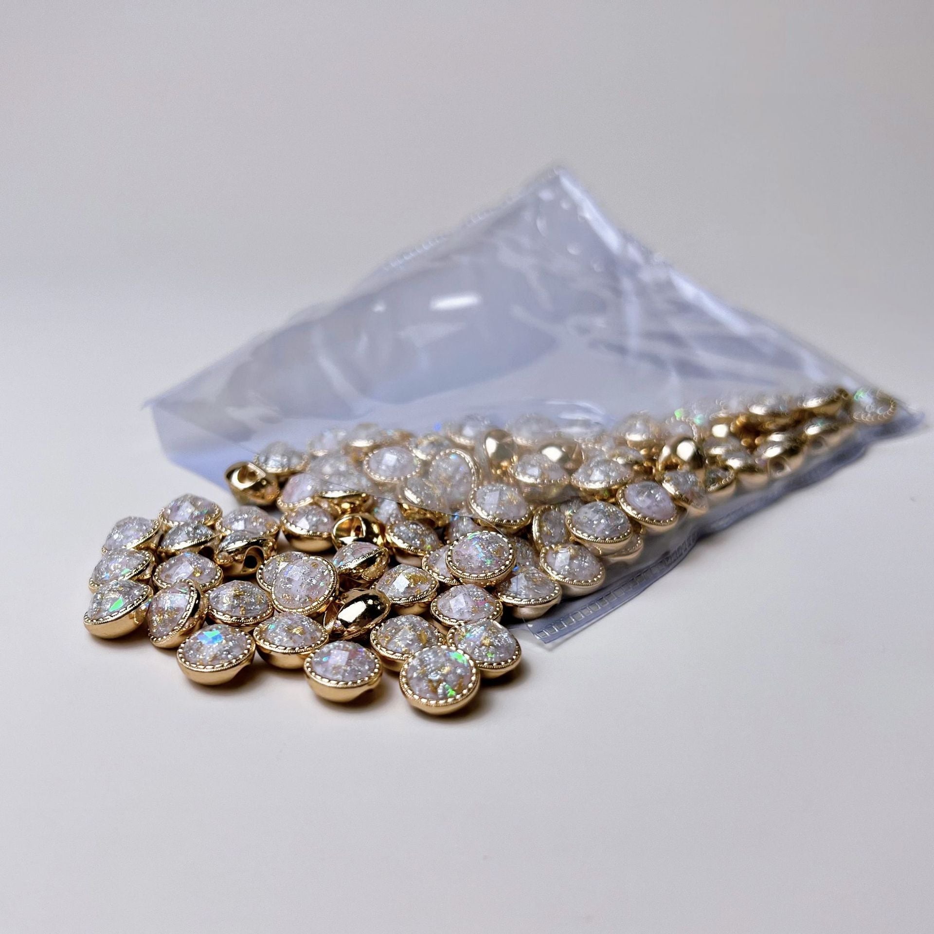 Beutel mit Metallhemdknöpfen 10mm, goldfarbene Fassungen und irisierendem Stein