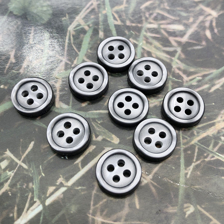 Round resin shirt buttons, 4-hole, light grey tone, front faces showing 4 holes