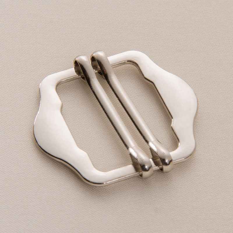 Silver metal slide buckle with double pins, close-up, 1–3 cm