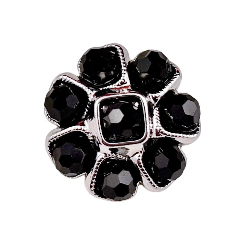 Blumenförmiger Metallknopf mit Perlen, schwarze Steine und silberfarbenem Rand