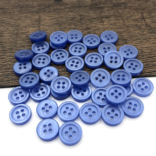 10mm light blue round buttons with four holes, pile scattered on a wooden surface