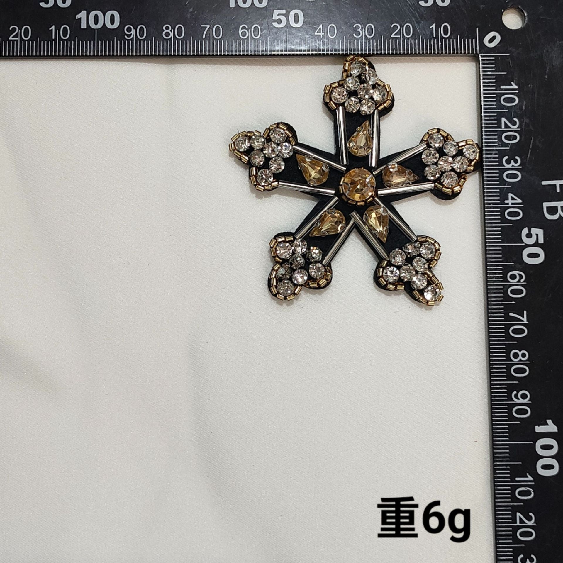 Black fabric starburst badge patch with rhinestones and gold-tone beaded border
