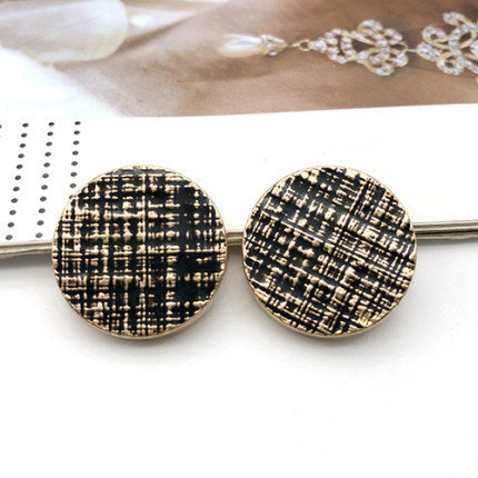 Pair of round coat buttons on metal pin, dark black-and-white striped pattern