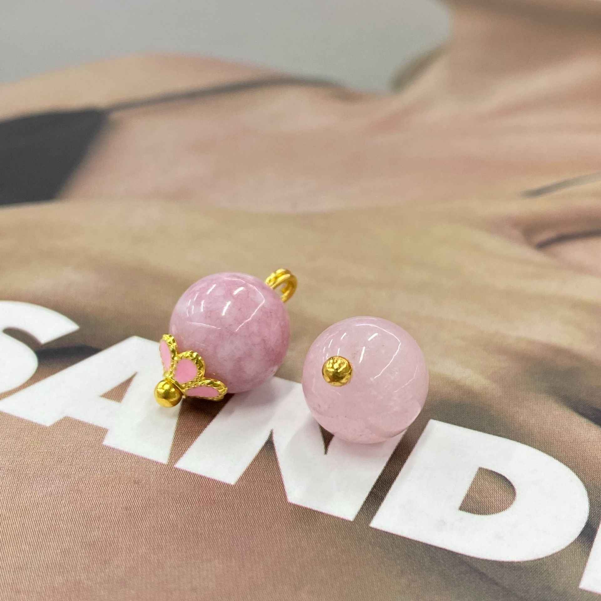 Pink jade-look ball button pair with gold-tone floral and plain loop shanks