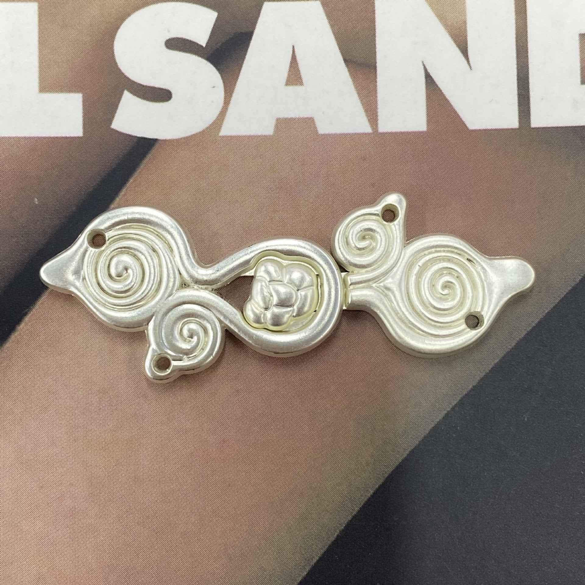 Silver-tone metal frog button (Style 6), spiral swirl panels with round center medallion