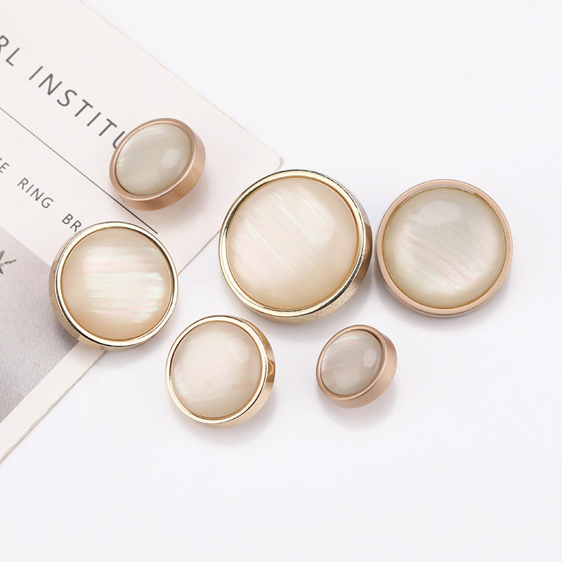 Cat-eye stone buttons set with round pearly fronts and shiny light gold metal borders