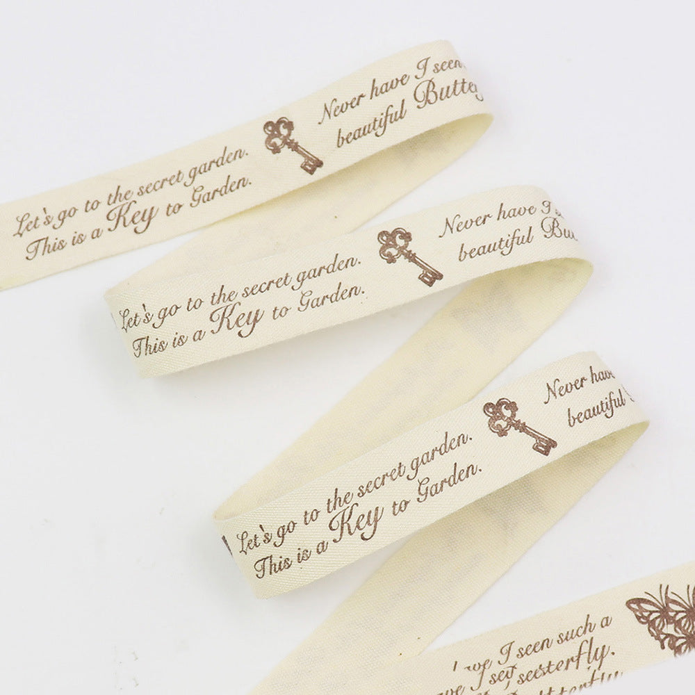 Cremefarbenes Bias Tape mit braunen Spruch-Prints und Schlüsselmotiven, mehrere Lagen (7er)