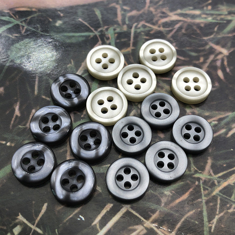 Round resin shirt buttons, 4-hole, grey and cream tones, laid out in a cluster