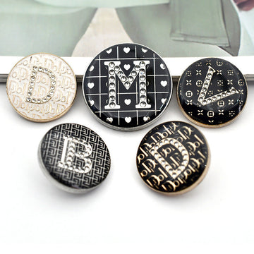 Set of round rhinestone letter buttons, black base with gold-toned edges (various styles)
