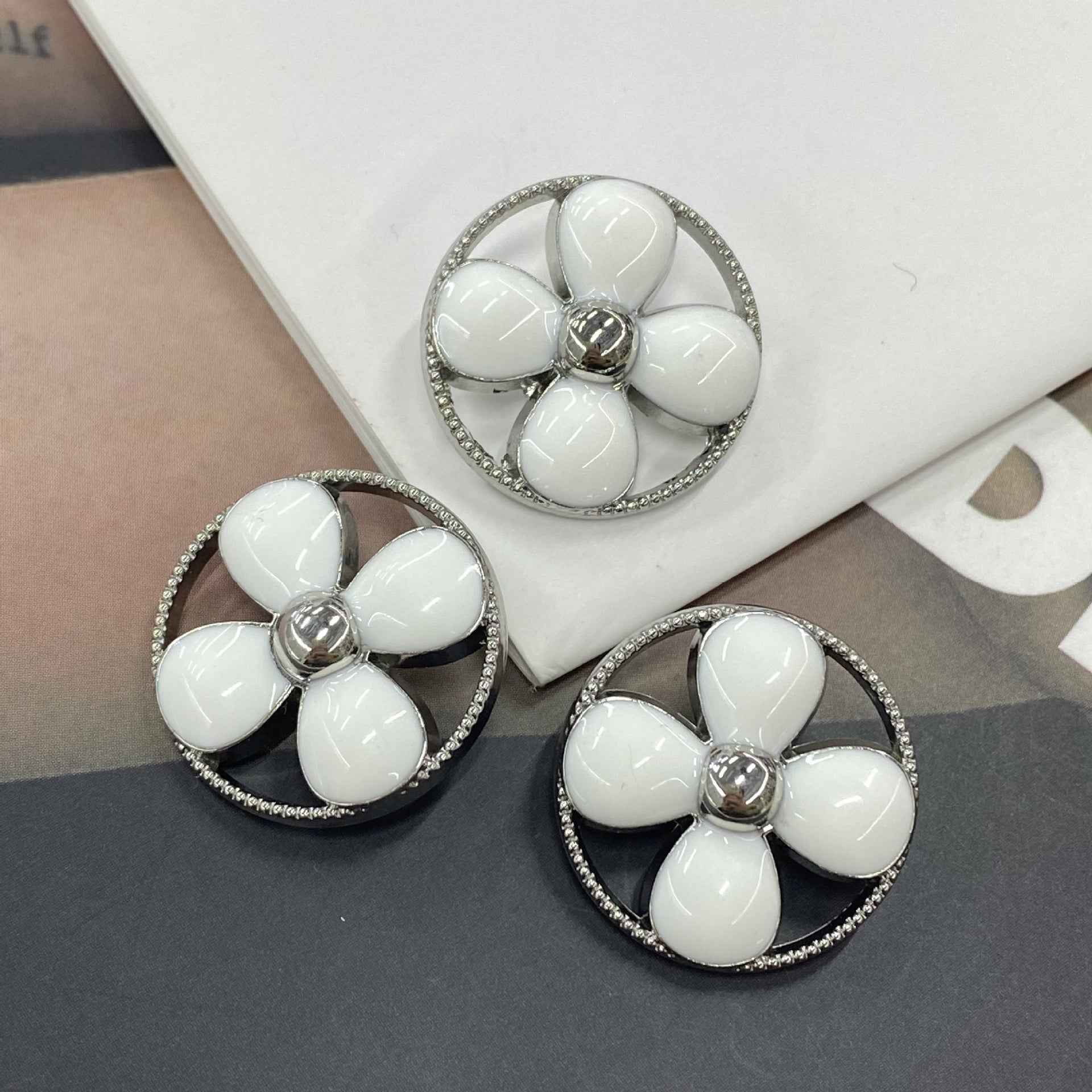Round clover shank buttons with white petals, silver-tone rim and central metal shank