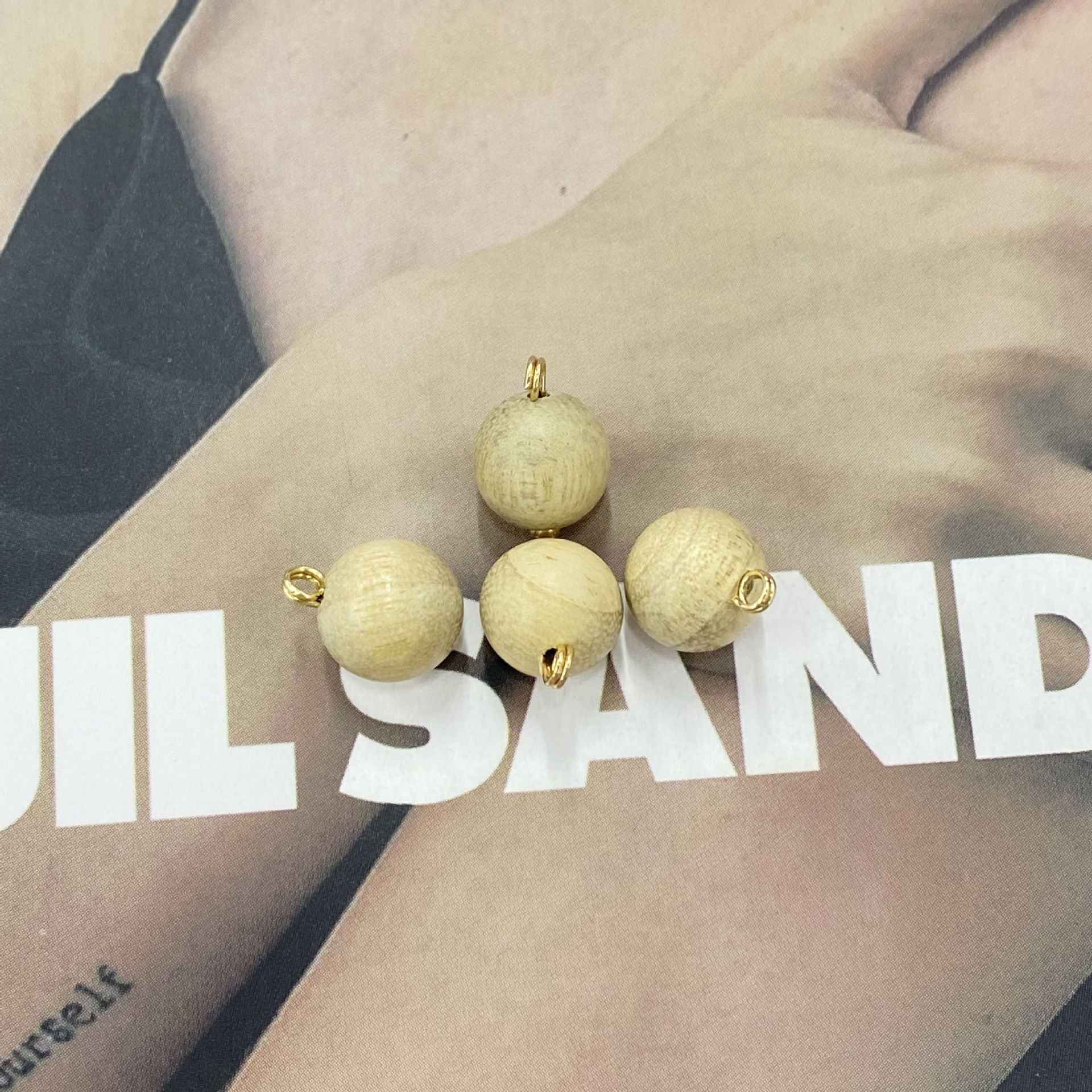 White/light round wooden buttons with gold-tone loops