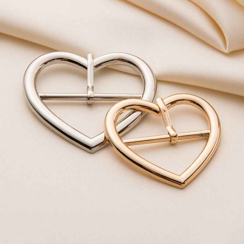 Heart-shaped metal roller buckles, silver and gold finishes shown together