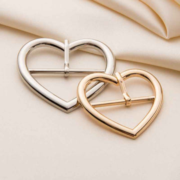 Heart-shaped metal roller buckles, silver and gold finishes shown together