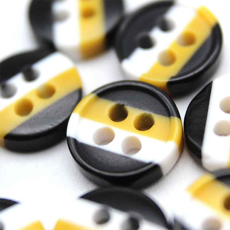 Assorted round 4-hole resin buttons in black, yellow and white, close-up