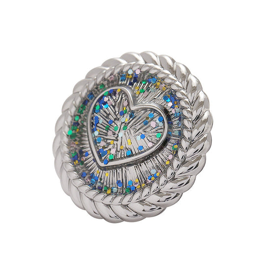 Silver heart-shaped metal shank button with braided rim and blue glitter mosaic center