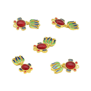 Goldfish-shaped decorative metal button with red oval center, blue/green accents, gold frame