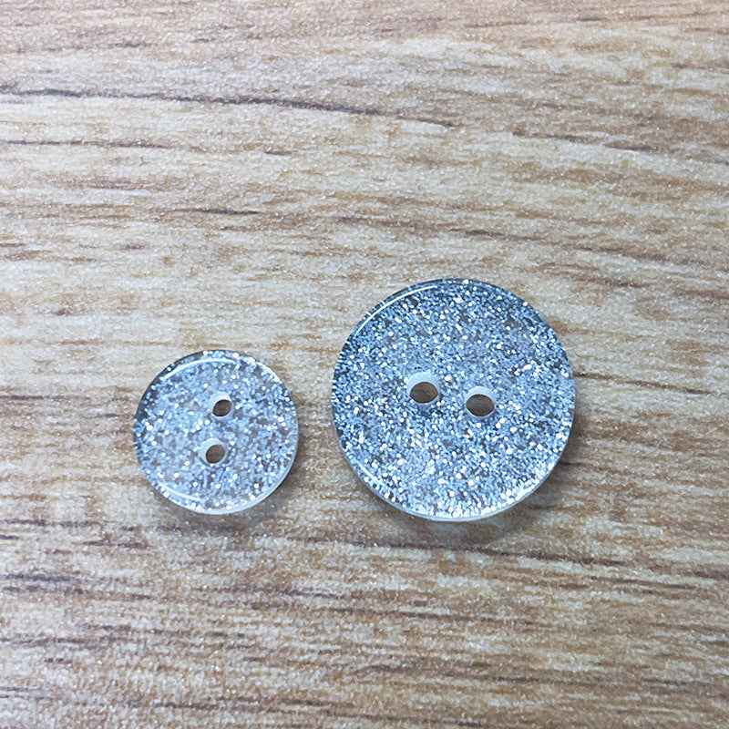 Two round 2-hole white transparent glitter resin buttons, different sizes