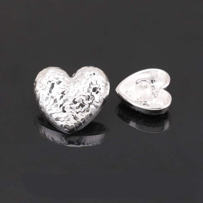 Heart-shaped textured metal shank button, bright silver hammered scale finish; back visible