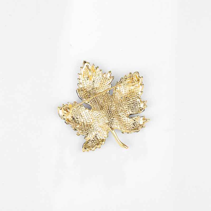 Gold-tone maple leaf brooch pin with rhinestone sparkle and gold-toned pin back