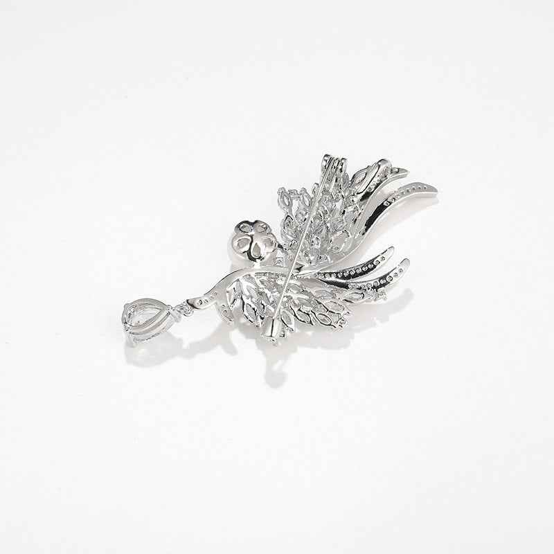 Silver wing brooch pin laid flat with clear gem accents and pearl centerpiece